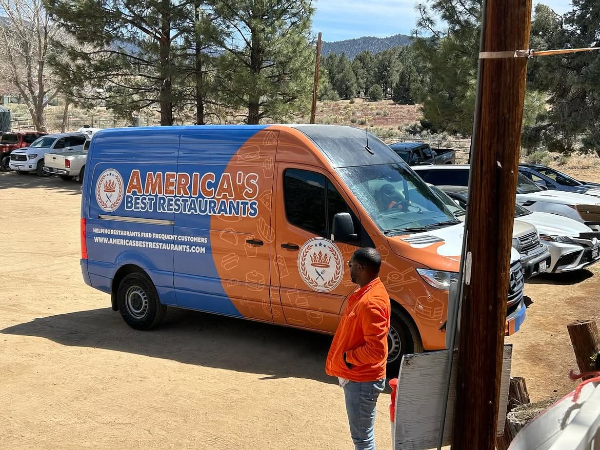 The America's Best Restaurants crew van parked outside on the dirt lot