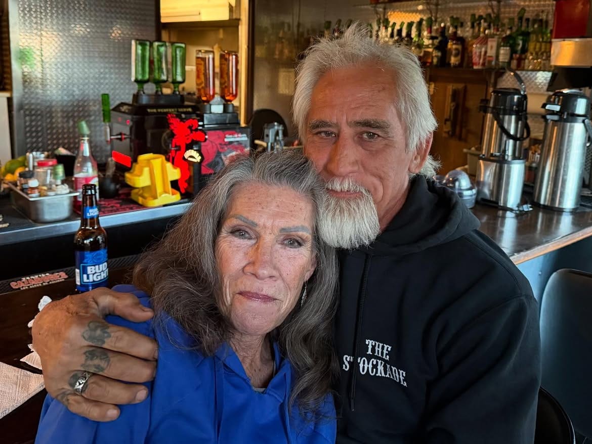 A couple leaning together at the bar