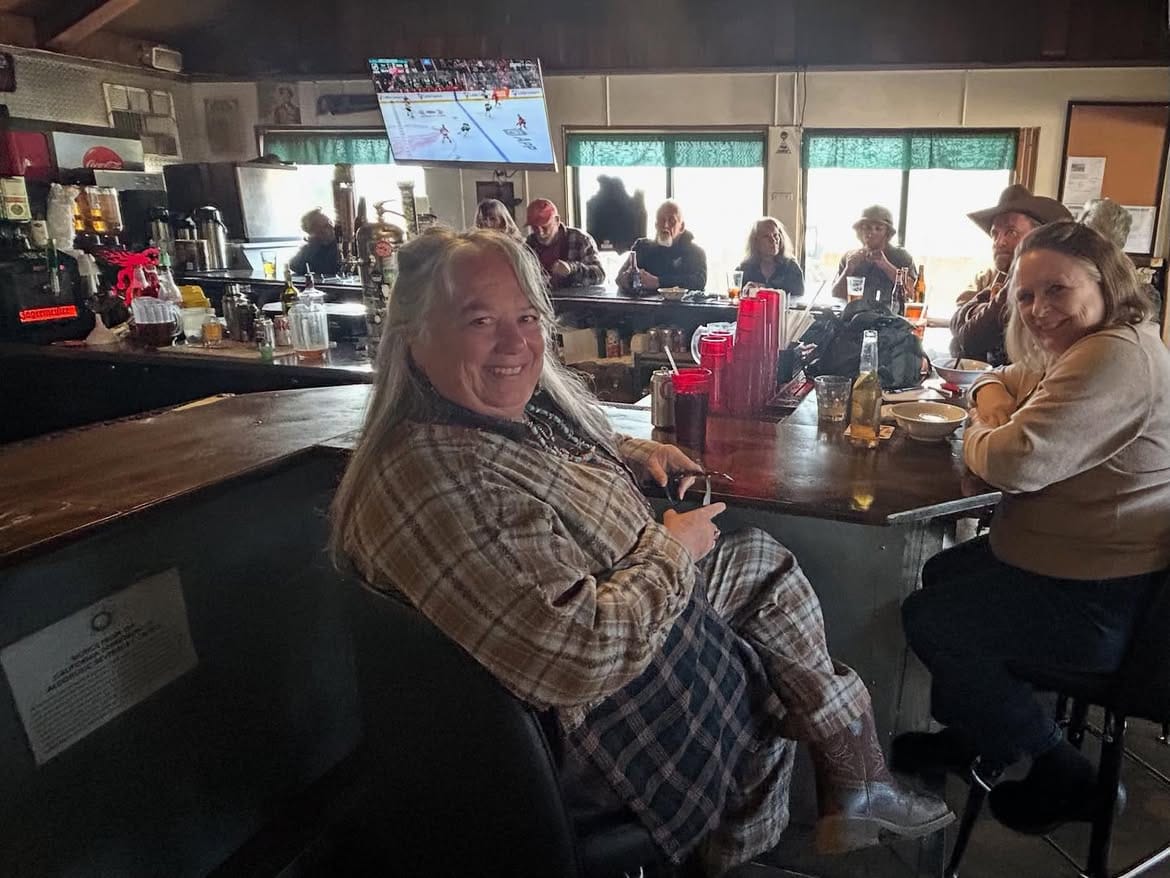 A guest seated at the bar, the room busy behind her