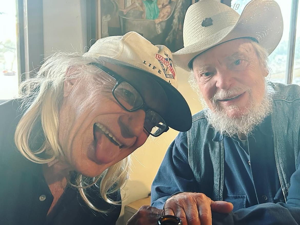 Two long-time regulars in hats, close to the camera and laughing