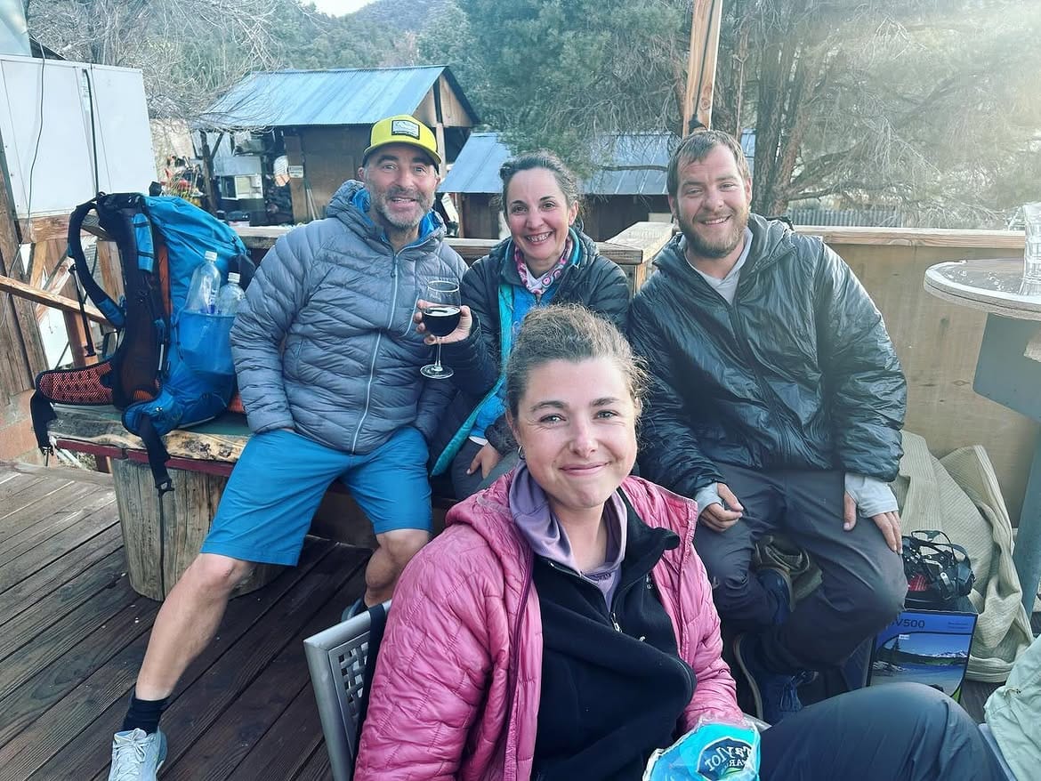 A group of hikers with their packs down, drinks in hand